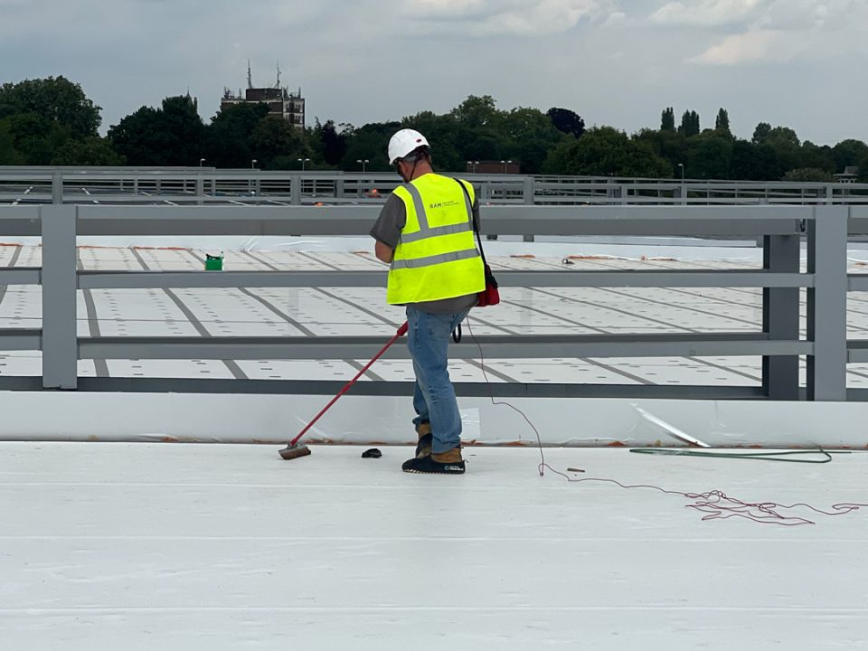 RAM Building Consultancy technician conducting a Dynamic Leak Investigation on a flat commercial roof.